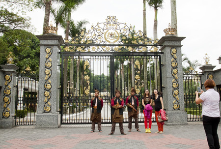 KUALA LUMPUR, MALAYSIA - FEBRUARY 17  Tourists taking photo with armed guards in traditional Malay costume at the entry gate of Royal Museum in Kuala Lumpur, Malaysia on February 17, 2013のeditorial素材