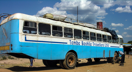 Near Chengi, Zambia, 11th June 2005: Men changing spare tyre of travel busのeditorial素材