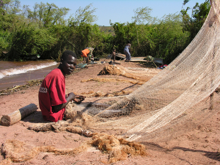 Near Pweto, Katanga, Democratic Republic of Congo, 12th June 2005: Fisherman repairing his net by Lake Mweru shoreのeditorial素材