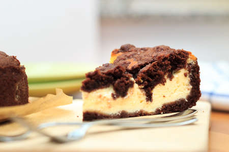 Cheesecake with chocolate shortcrust pastry and chocolate crumble arranged on a wooden boardの写真素材
