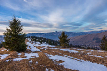 Sunset spring Carpathian mountains landscape with snow-covered ridge.