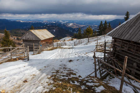 winter mountain landscape with wooden houses on a sunny morningの写真素材