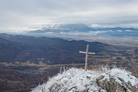 Wooden cross on the mountain covered with white snow in wintertimeの写真素材