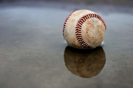 home run - a baseball in a puddle outside the parkの写真素材