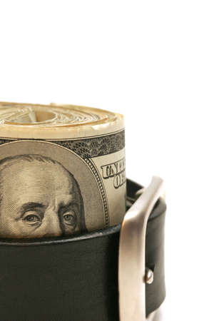 tightening the belt - belt tightened around a roll of bank notes. macro over white with shallow depth of field.の写真素材