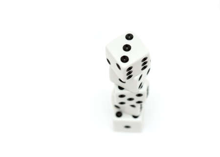 stacke of dice, highkey macro shot over white with shallow depth of field and focus on top diceの写真素材