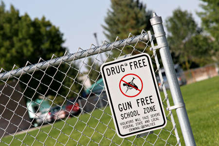 drug and gun free school zone sign at a school yard. sign of the times.の写真素材