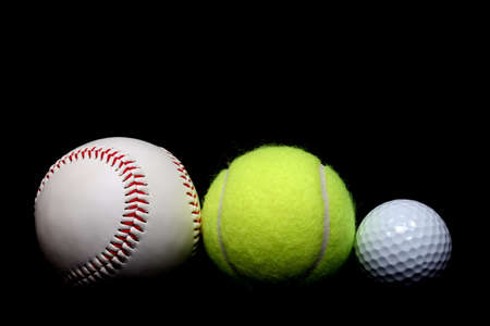 ball sports - a base ball, tennis ball, and golf ball side by side, close up over blackの写真素材
