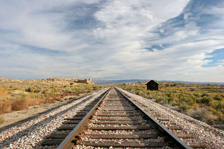 looking down the train tracks. landscape in the midwest with a small cabin alongsideの写真素材