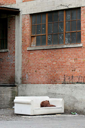 old couch in an abandoned industrial area frequented by the homelessの写真素材