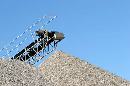 conveyor over heaps of gravel at an industrial cement plantの写真素材