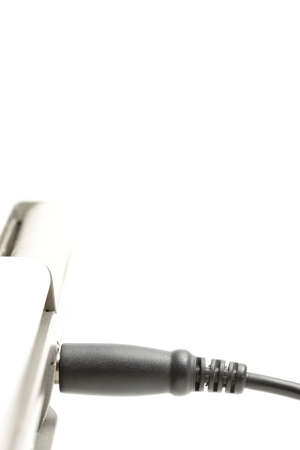 laptop charging - plugged in. highkey macro over white with focus on plug