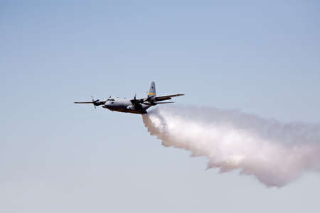 fire fighting aircraft - hercules C130 releases its load of waterの写真素材