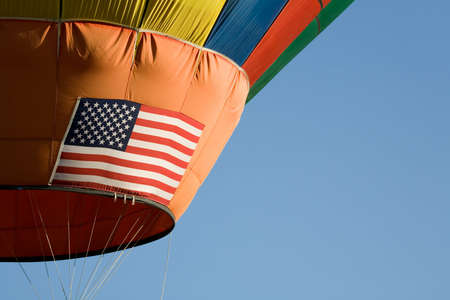 hot air balloon with big united states flag on its side. blue sky background with copyspace.の写真素材