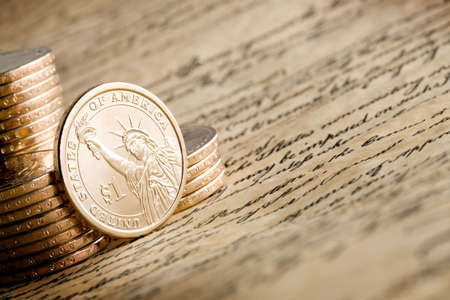 dollar coin depicting the Statue of Liberty, golden against stack, on the United States Constitutionの写真素材