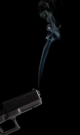 smoking gun - modern 9mm handgun with rising smoke from barrel, closeup on blackの写真素材