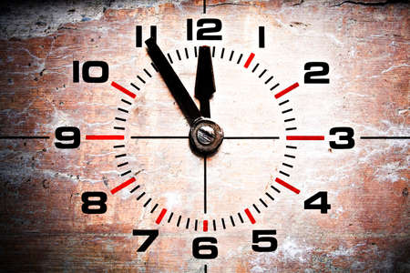 five to twelve - old industrial clockface showing 11:55 on grunge brick backgroundの写真素材