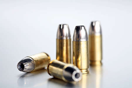 bullets 9mm - closeup of 9mm silvertipped rounds on a cold brushed metal backgroundの写真素材
