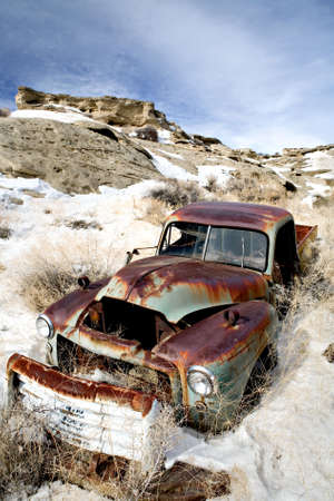abandoned vintage car rusting away in the snowの写真素材