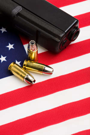 handgun and bullets closeup on American flagの写真素材