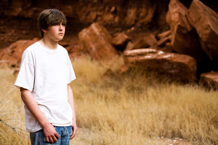 teen boy in Wyoming wilderness area, large red-brown boulders in background, copyspaceの写真素材