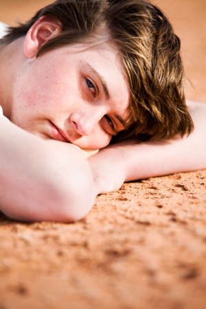 teen male laying on the ground looking into camereaの写真素材