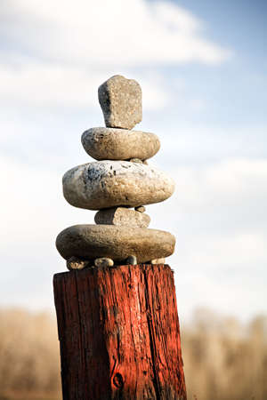 zen western style - stones balanced on old painted fence post in rural Montana