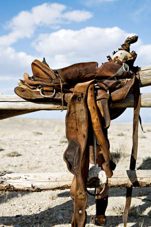 saddle on a fence - a vintage saddle in rural Wyomingの写真素材