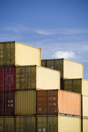 shipping freight containers stacked in port against blue sky