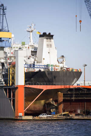 ship in dry dock - large container ship rear view with propeller under repair