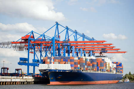 container ship in port terminal - huge freighter fully loaded