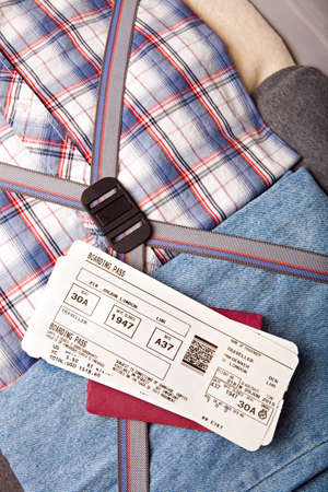 boarding pass and passport on packed suitcaseの写真素材