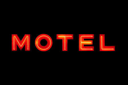 motel sign neon retro closeup isolated on solid blackの写真素材