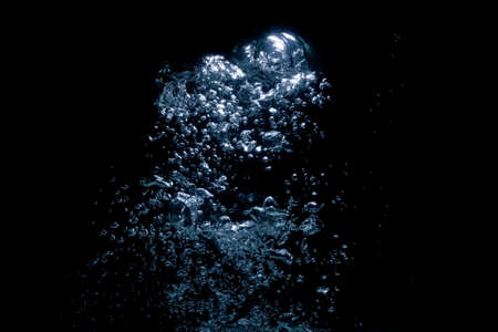 air bubbles close up rising in water over black background