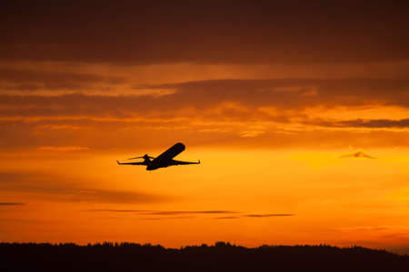 airplane taking off in sunsetの写真素材