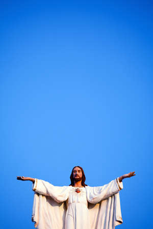 Jesus against clear blue sky, on old church.の写真素材