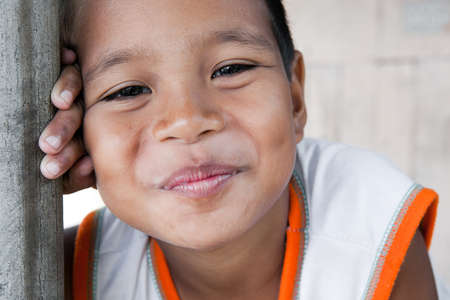 Portrait of a smiling boy in the Philippines from an impoverished neighborhood.の写真素材