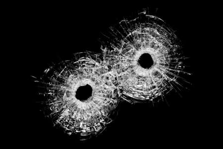 bullet holes in glass - authentic bullet holes closeup isolated on blackの写真素材