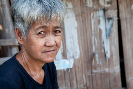 Asian senior from an impoverished area, outside her home in the Philippinesの写真素材