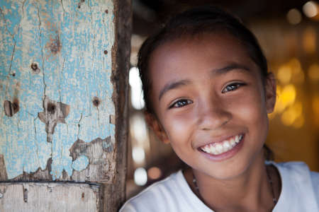Portrait of a smiling Filipina girl from impoverished neighborhood in the Philippines.の写真素材