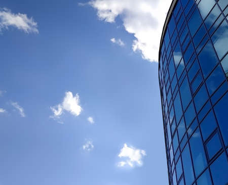 Office building with blue windows on sky background. Low angle of viewの写真素材