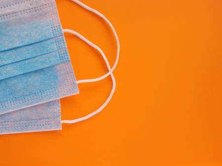 Sterile protective medical blue masks on a orange backgroundの写真素材