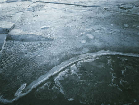 Cracked blue ice texture. Frozen surface of the lake