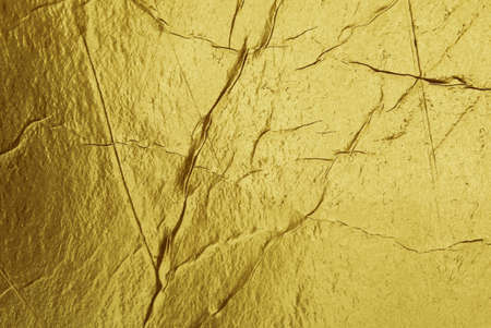 Grunge gold foil texture background with cracks and scratchesの写真素材