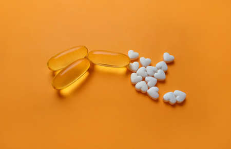 Supplements and vitamins close up on an orange background