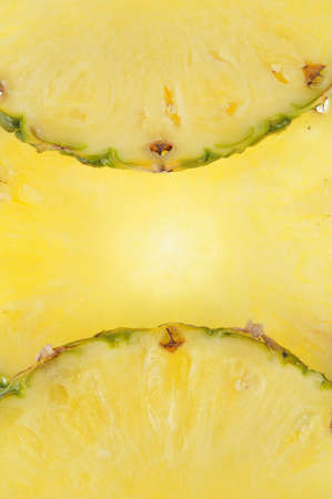 Round parts of pineapple as yellow backgroundの写真素材