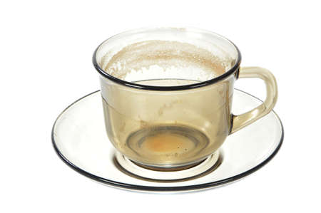 Dirty transparent coffee cup on saucer on white backgroundの写真素材