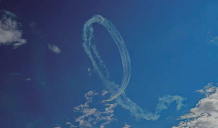 Inversion trail of the plane. A small plane makes a dead loop.の写真素材