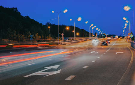 Lights of cars with night. Direction of traffic on the highway. A long exposure time. The arrow is straight and to the right.の写真素材