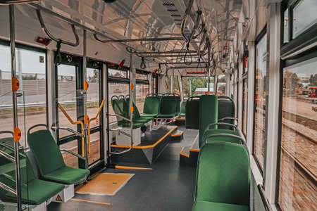 Interior design of a modern tram. Empty tram interior. Public transport in the city. Passenger transportation. Tram with green seats and metal handrails.の写真素材
